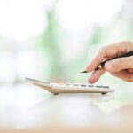 Hands of treasurer doing calculations with a calculator
